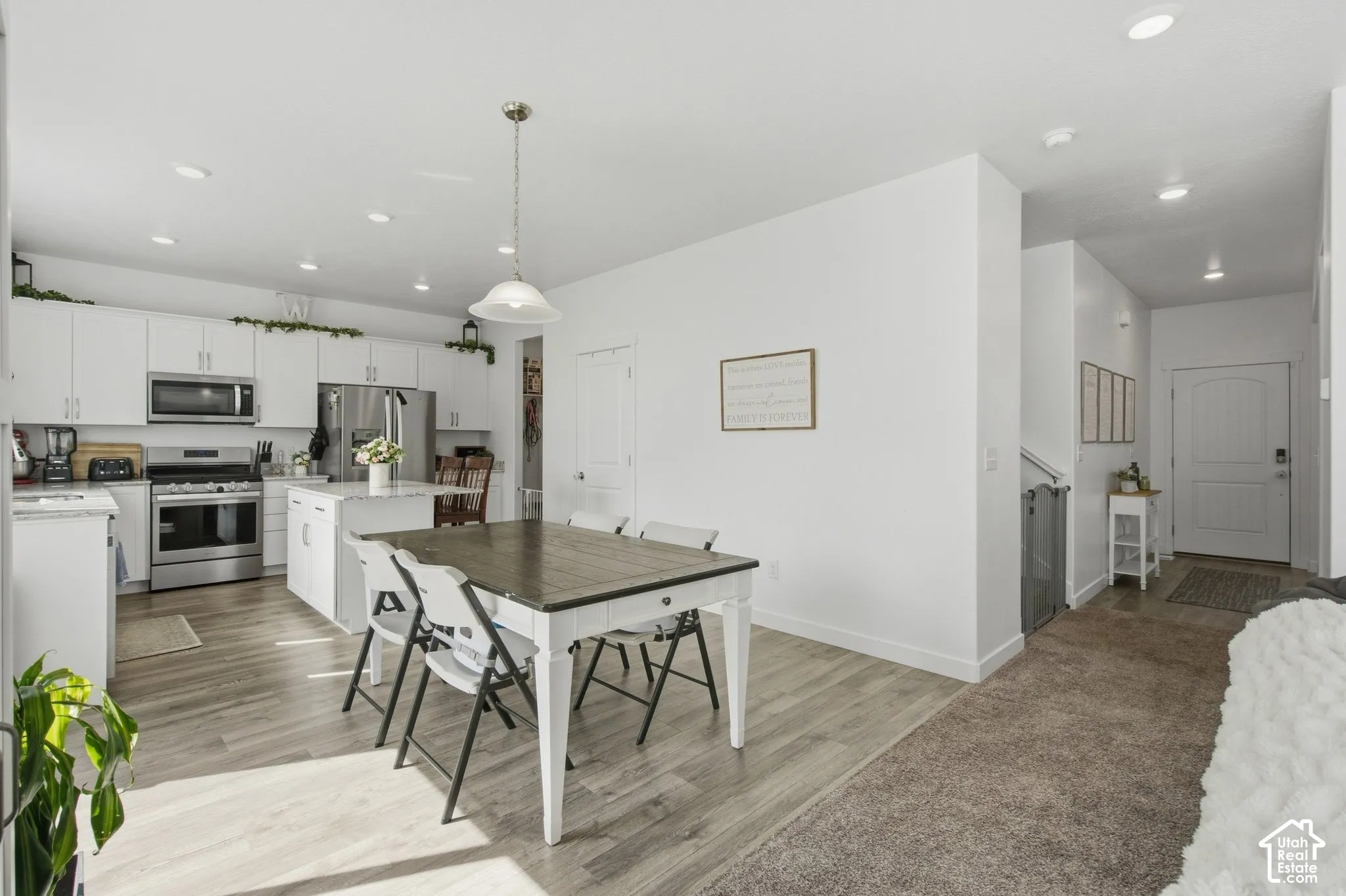 Open-concept kitchen with white cabinetry and stainless steel appliances