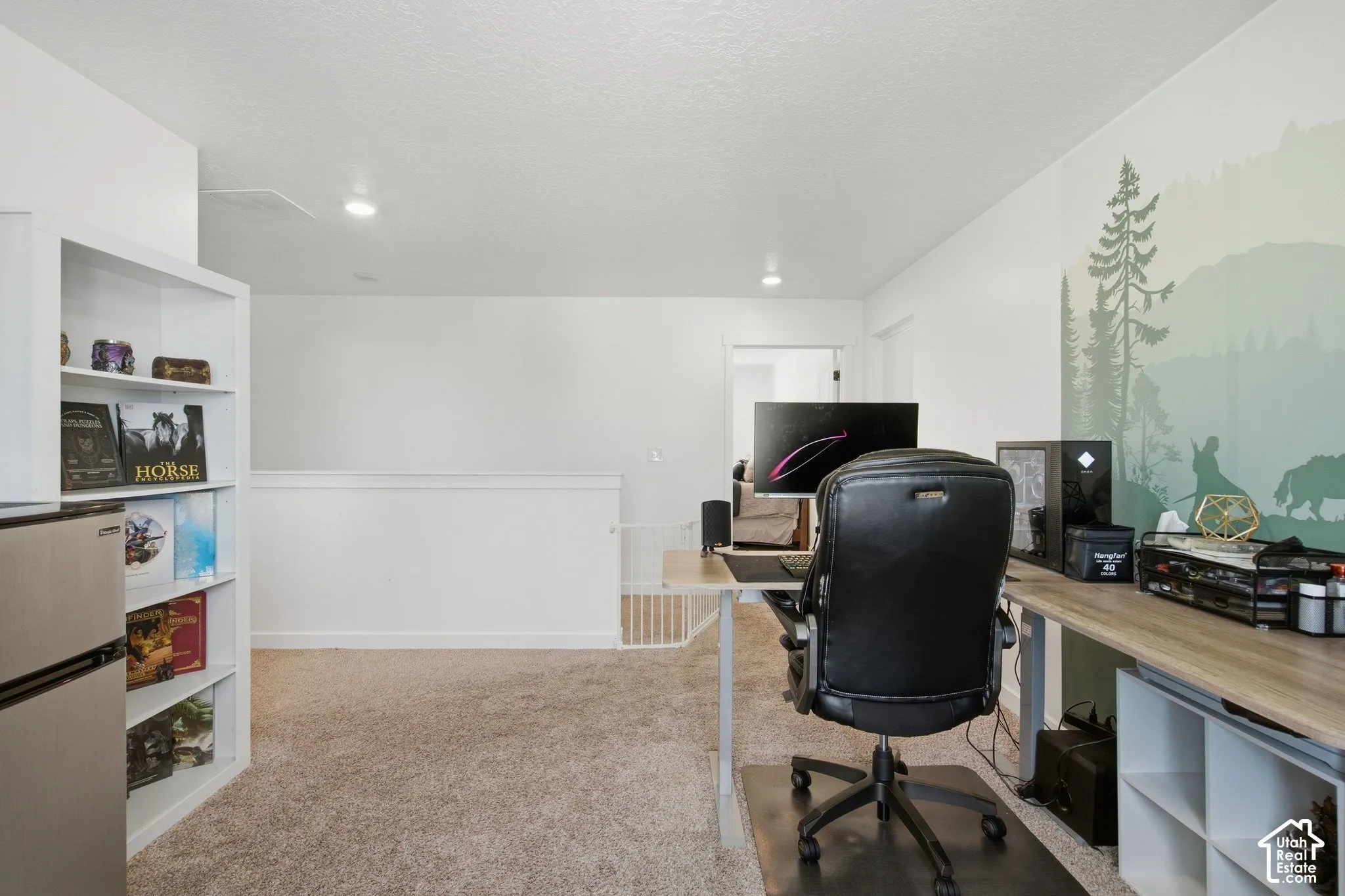 Carpeted space featuring a white built-in bookshelf, recessed lighting, and a painted accent wall
