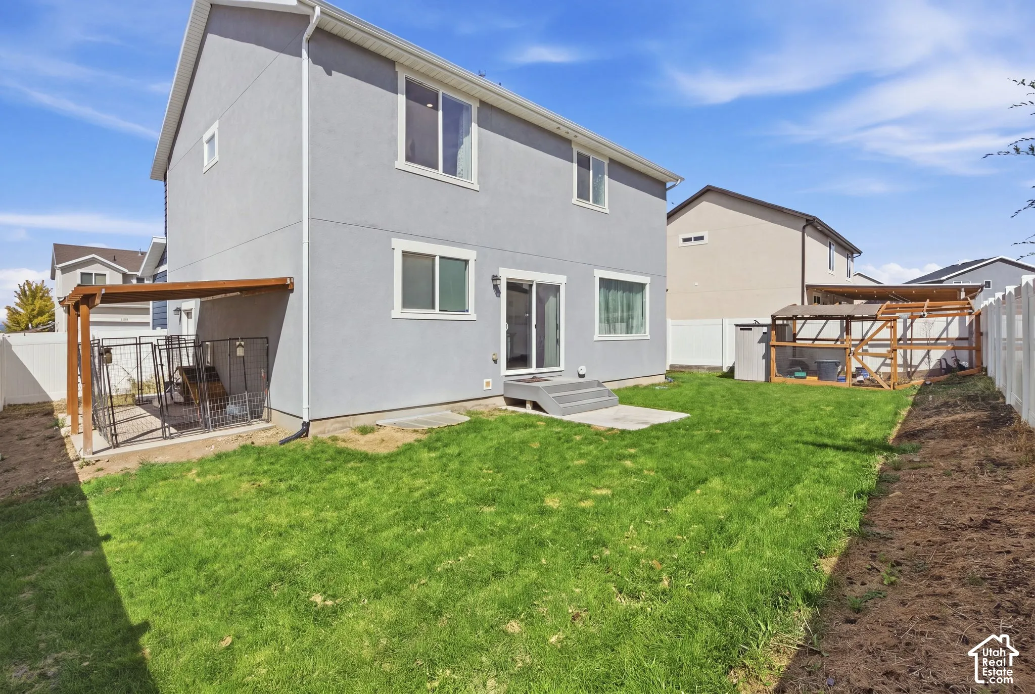 Rear exterior with a level lawn and privacy fencing