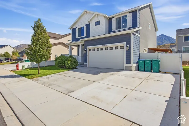 Two-story residence featuring blue siding, white trim, and an attached two-car garage