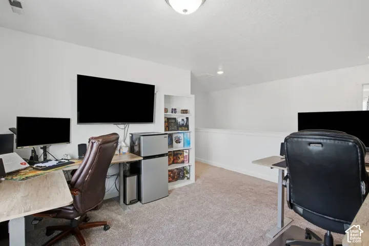Carpeted room with white walls, built-in shelving, and a white half-wall