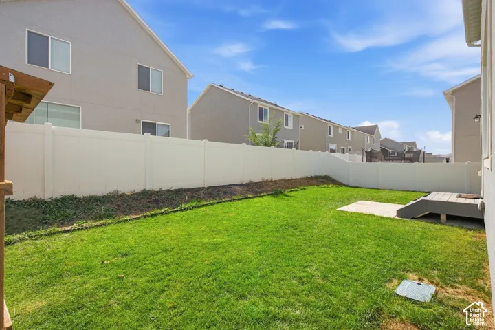 Expansive green lawn, durable privacy fencing, and a built-in outdoor deck with steps