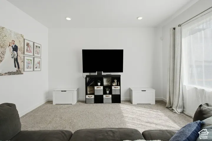 Recessed lighting, light-toned carpeting, and white painted walls