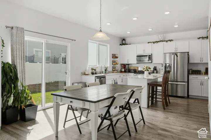Open-concept kitchen and dining area featuring white cabinetry and stainless steel appliances