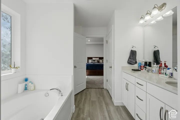 White double vanity with a light countertop, integrated sink, and an expansive mirror