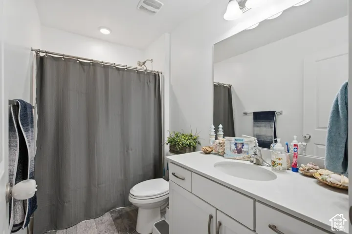 White single vanity with undermount sink, overhead lighting, and wall-mounted mirror