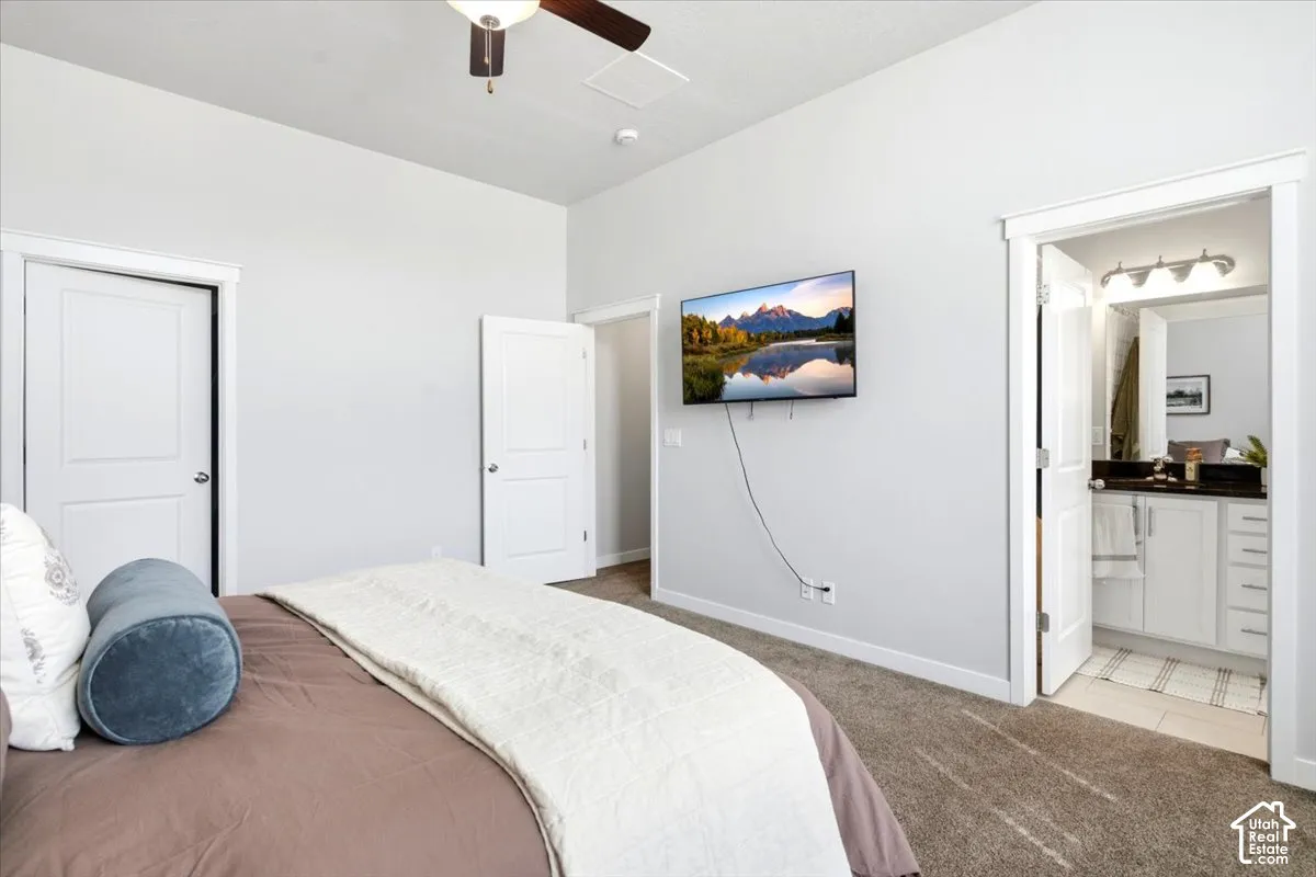 Carpeted flooring, vaulted ceiling, and an attached three-light vanity