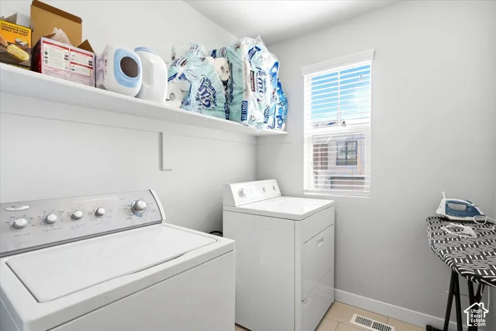 Laundry room featuring built-in shelving, a single window, and light-toned flooring