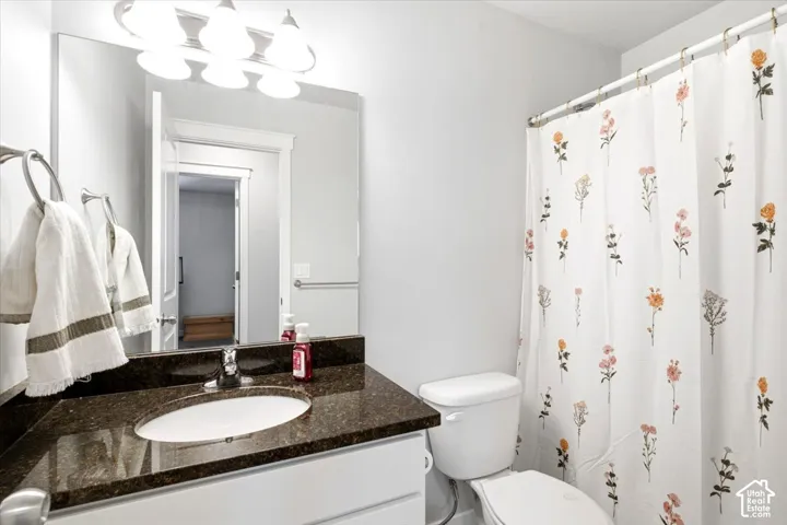 White vanity with an integrated sink and dark speckled countertop