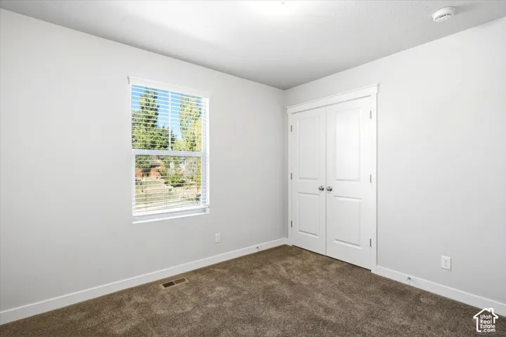 Bright interior with neutral wall finishes, carpeted flooring, and a window with blinds