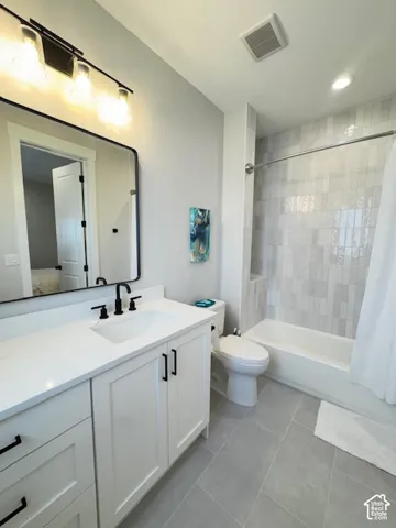 White vanity with dark hardware, undermount sink, and light countertop