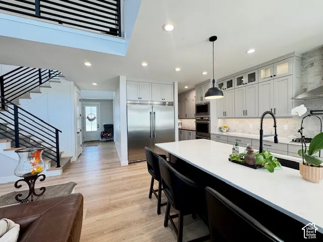 Open-concept kitchen with light-toned cabinetry, stainless steel appliances, and a large central island