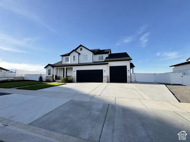 White two-story residence with black roof and trim, featuring a partial stone facade
