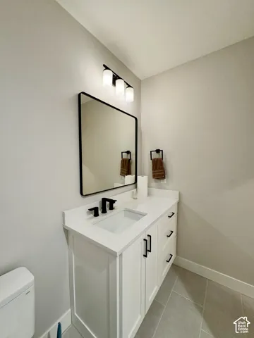 White shaker-style vanity with a solid surface countertop and undermount sink