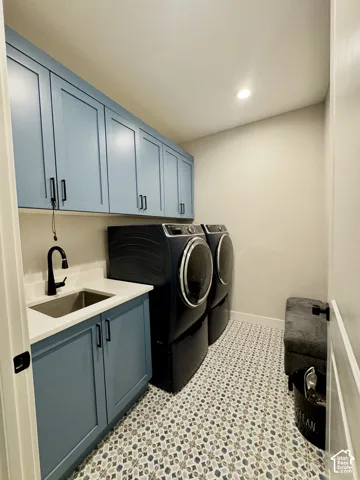 Patterned tile flooring, recessed ceiling lighting, light blue cabinetry, integrated sink, and a matte black faucet