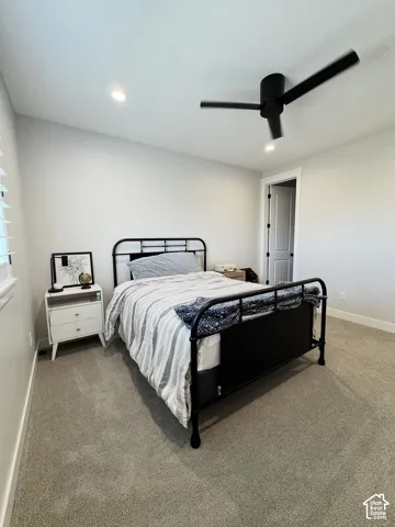 Recessed ceiling lighting, sloped ceiling, ceiling fan with integrated lighting, window with blinds, and light gray carpet flooring