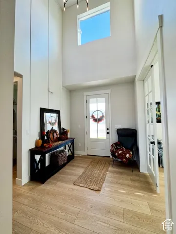 Two-story entryway with a transom window and light wood-finish flooring