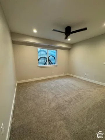 Recessed lighting fixtures, a modern ceiling fan, and light-colored carpeting