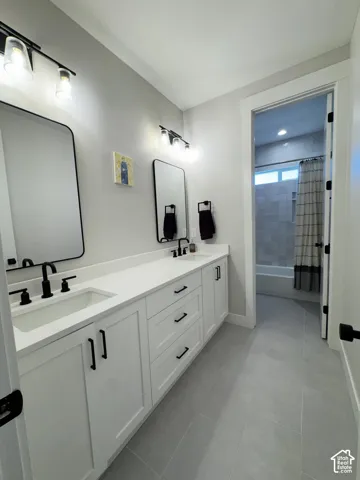Dual vanity with white cabinetry, matte black hardware, and an integrated rectangular sink