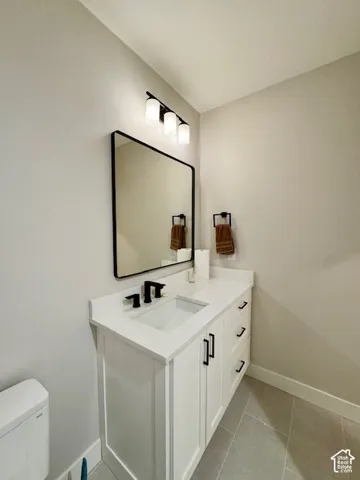 White vanity with shaker-style cabinetry, a white countertop, and a rectangular undermount sink