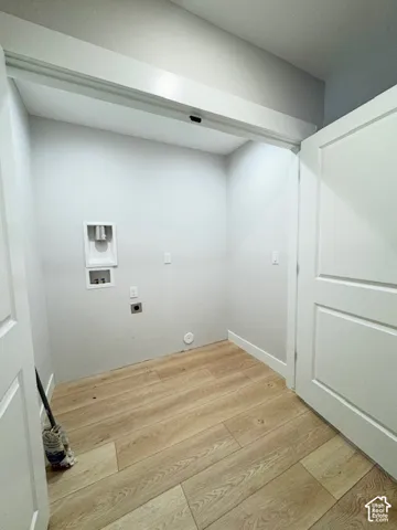 Laundry area featuring wood-finish flooring and a utility hookup