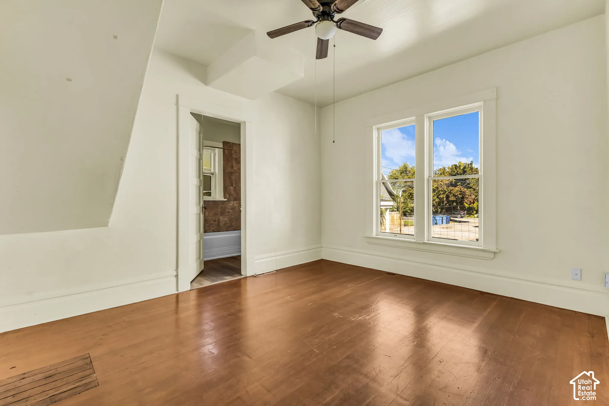 Hardwood flooring, painted walls, attic ceiling, twin windows, ceiling fan