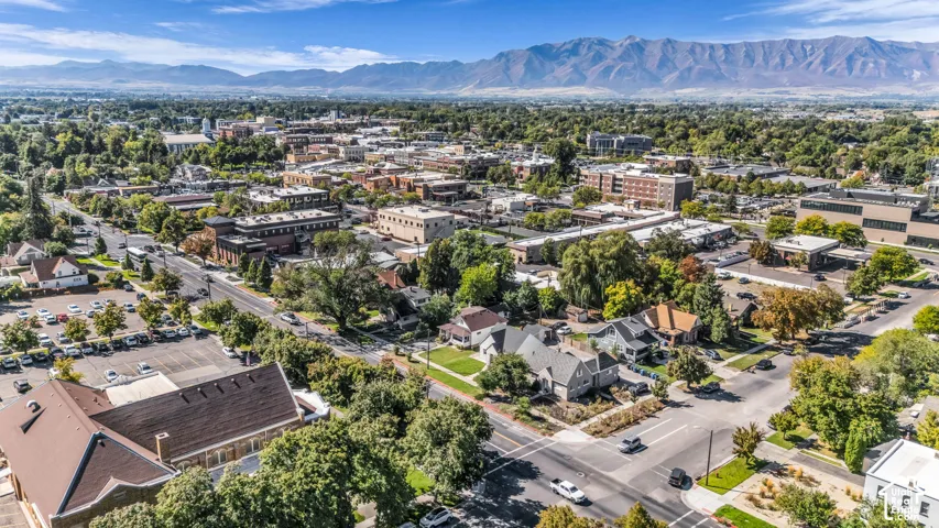 Dense urban area with varied architectural styles, established landscaping, and mountain backdrop