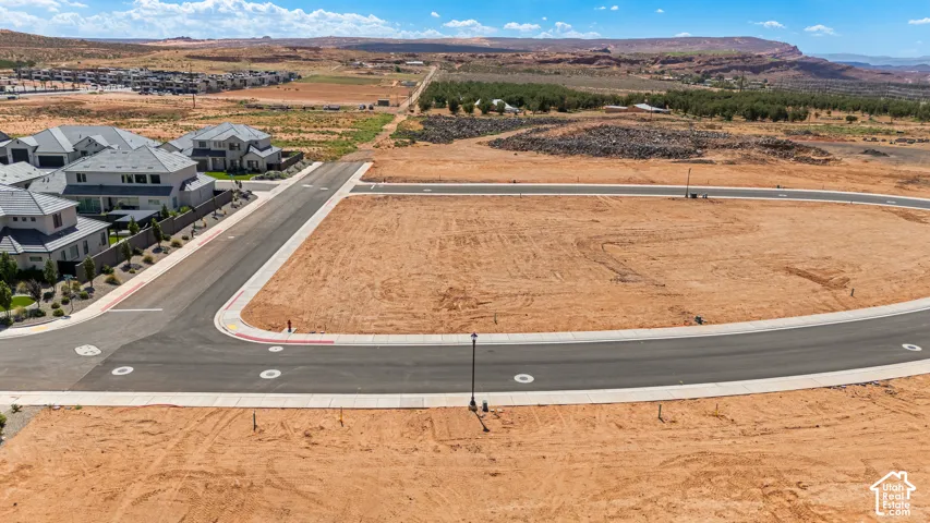 Expansive undeveloped lot with street access, surrounded by new construction homes and natural desert landscape