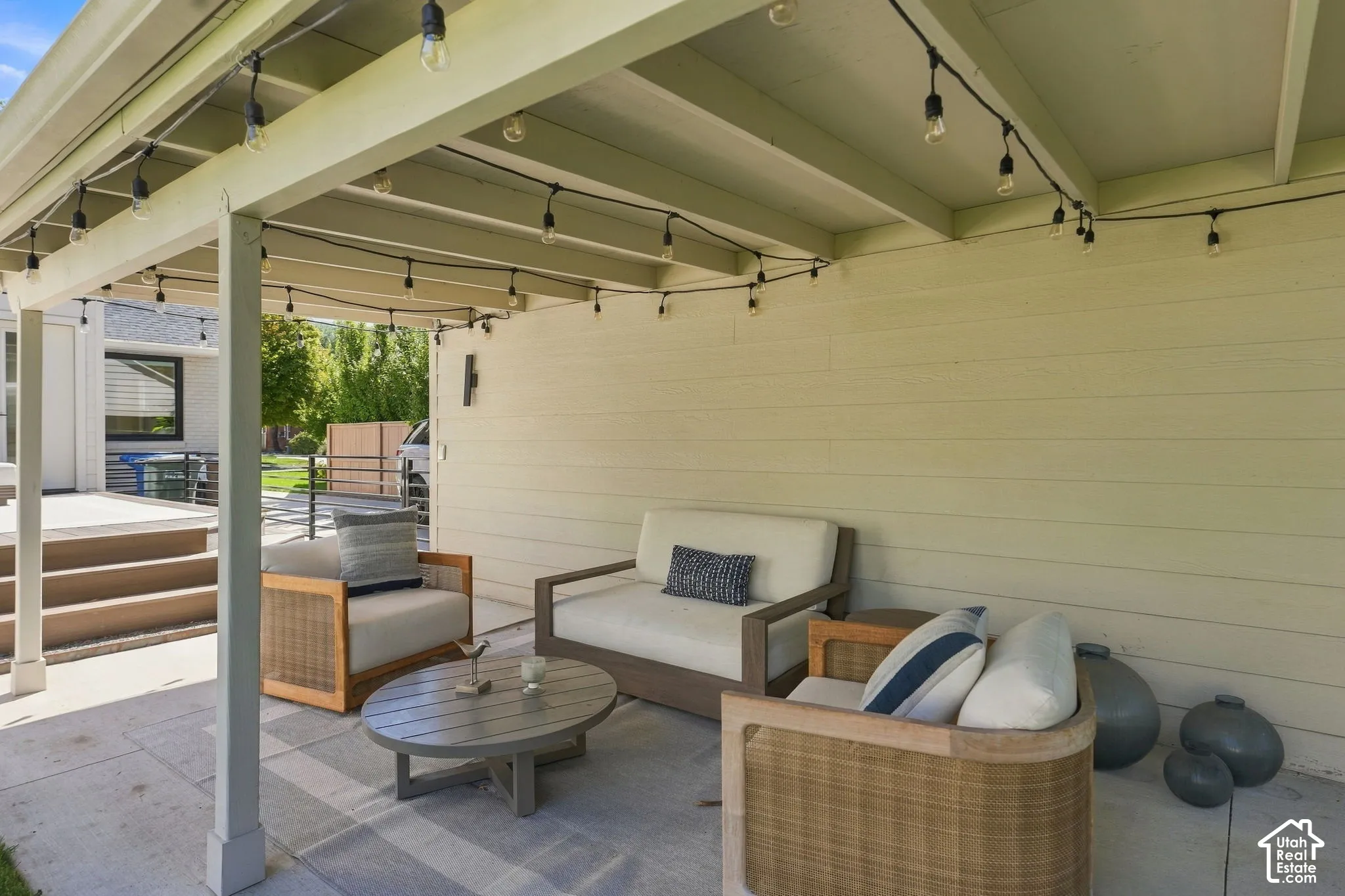 Covered patio with string lighting, a concrete surface, and exterior siding