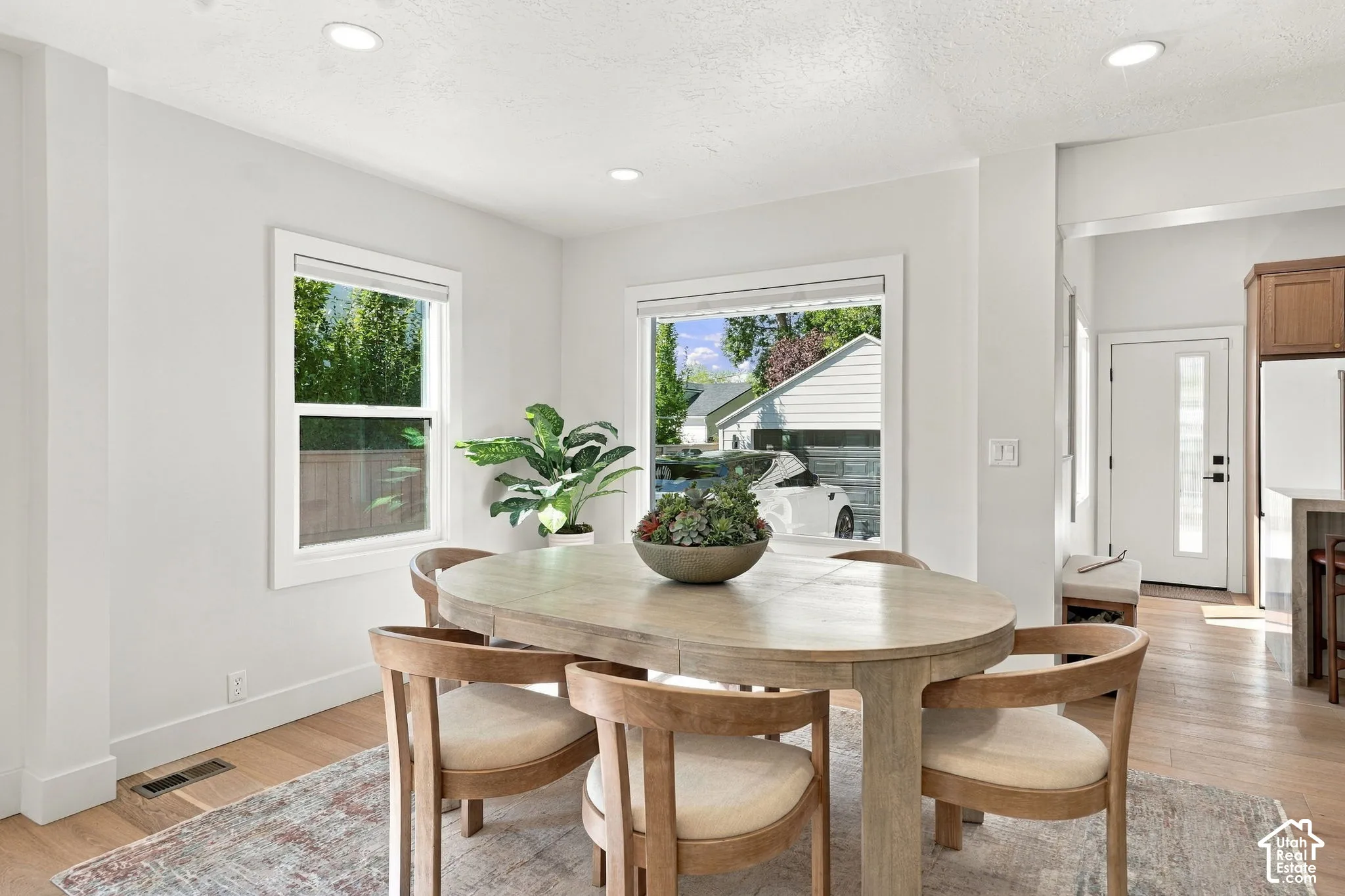 Recessed lighting illuminates the space, featuring light wood-finish flooring