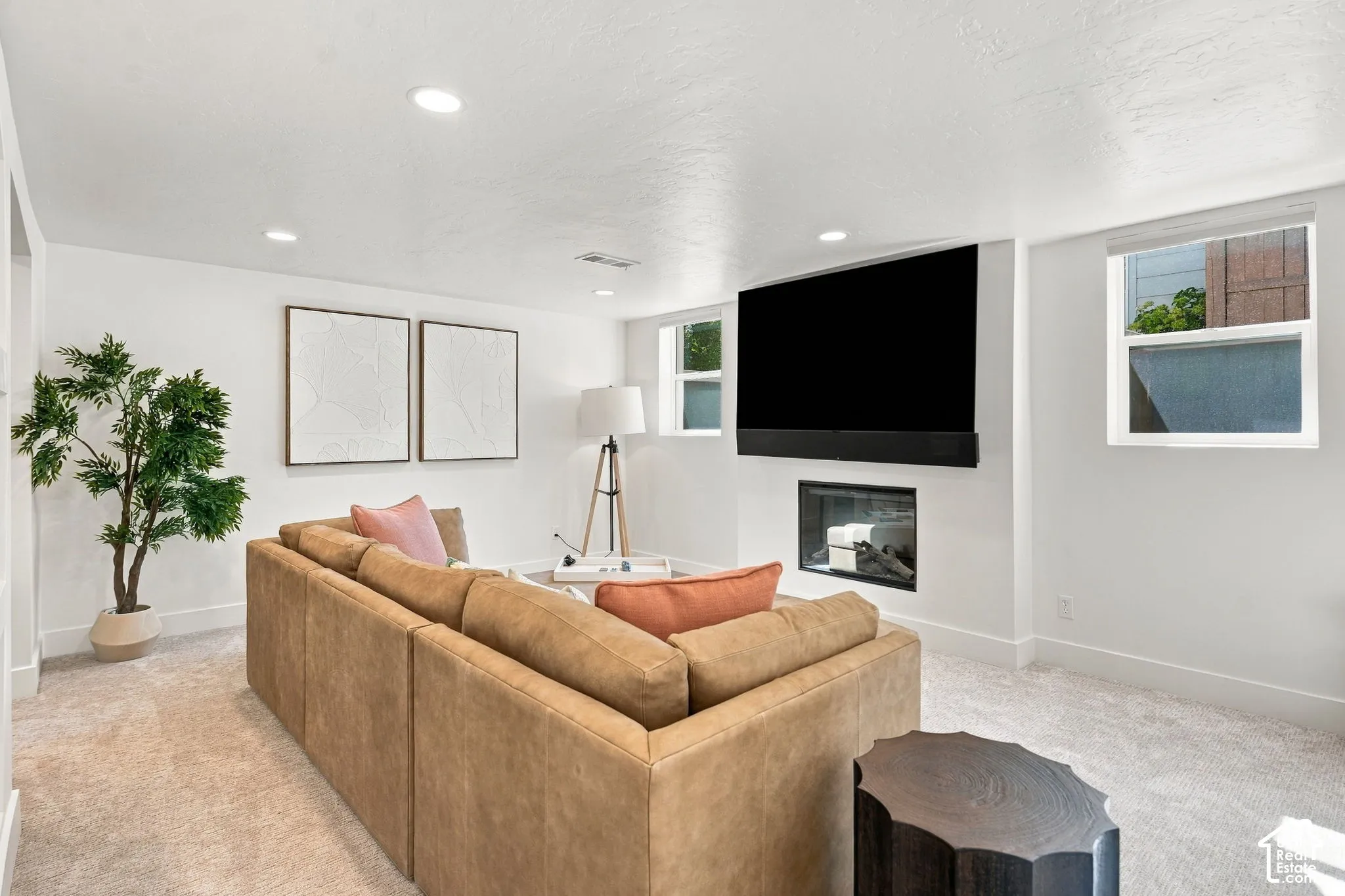 Recessed lighting, light-toned carpeting, built-in fireplace, and expansive windows
