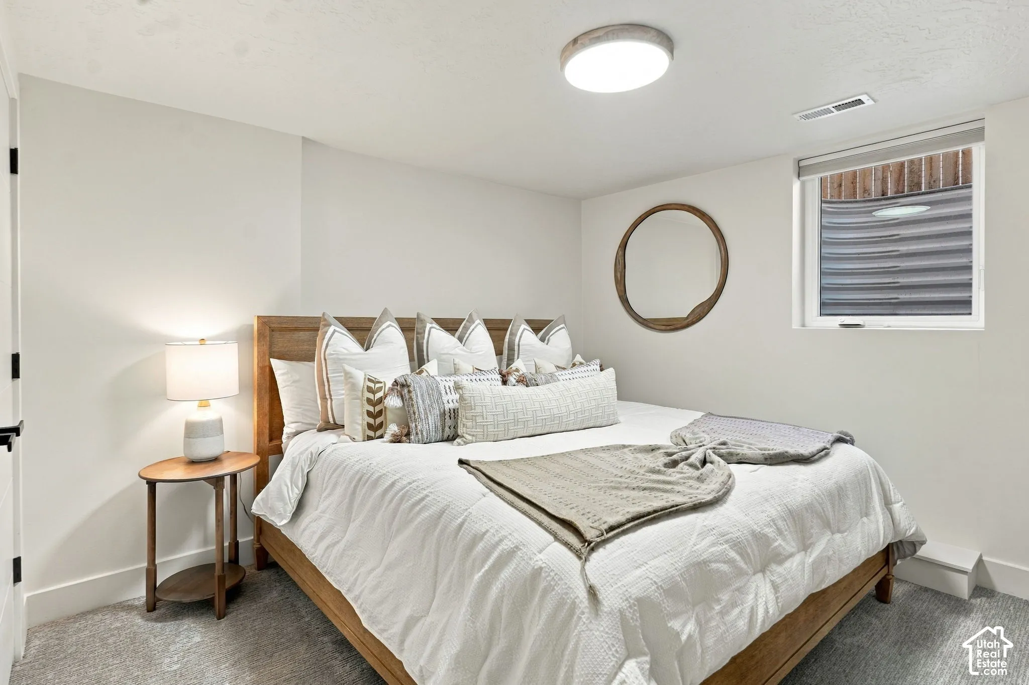 Light-colored carpeting with a window and roller shade