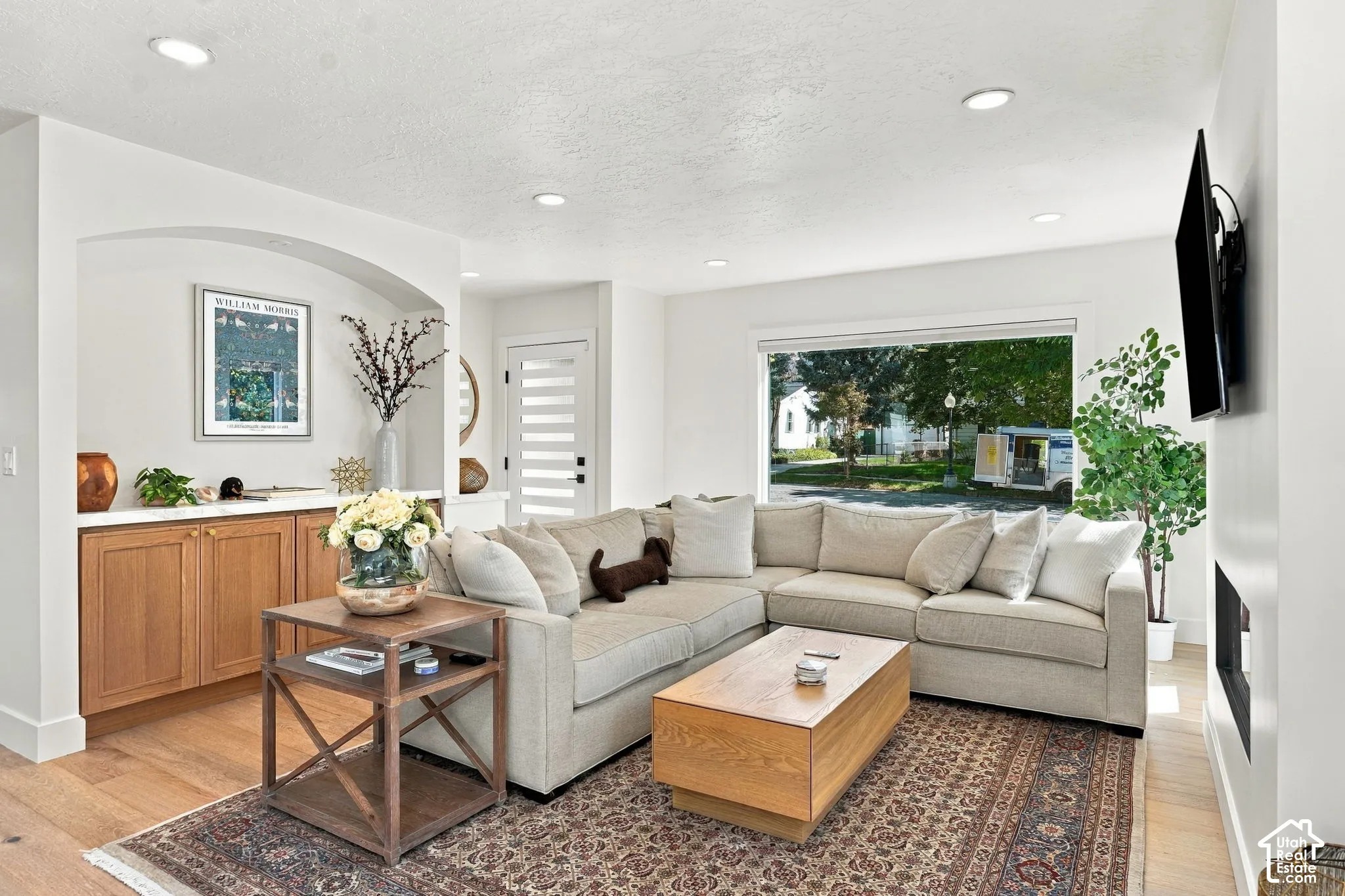 Recessed lighting, wood-finish flooring, built-in cabinetry with a countertop, expansive window, and modern door with horizontal lites