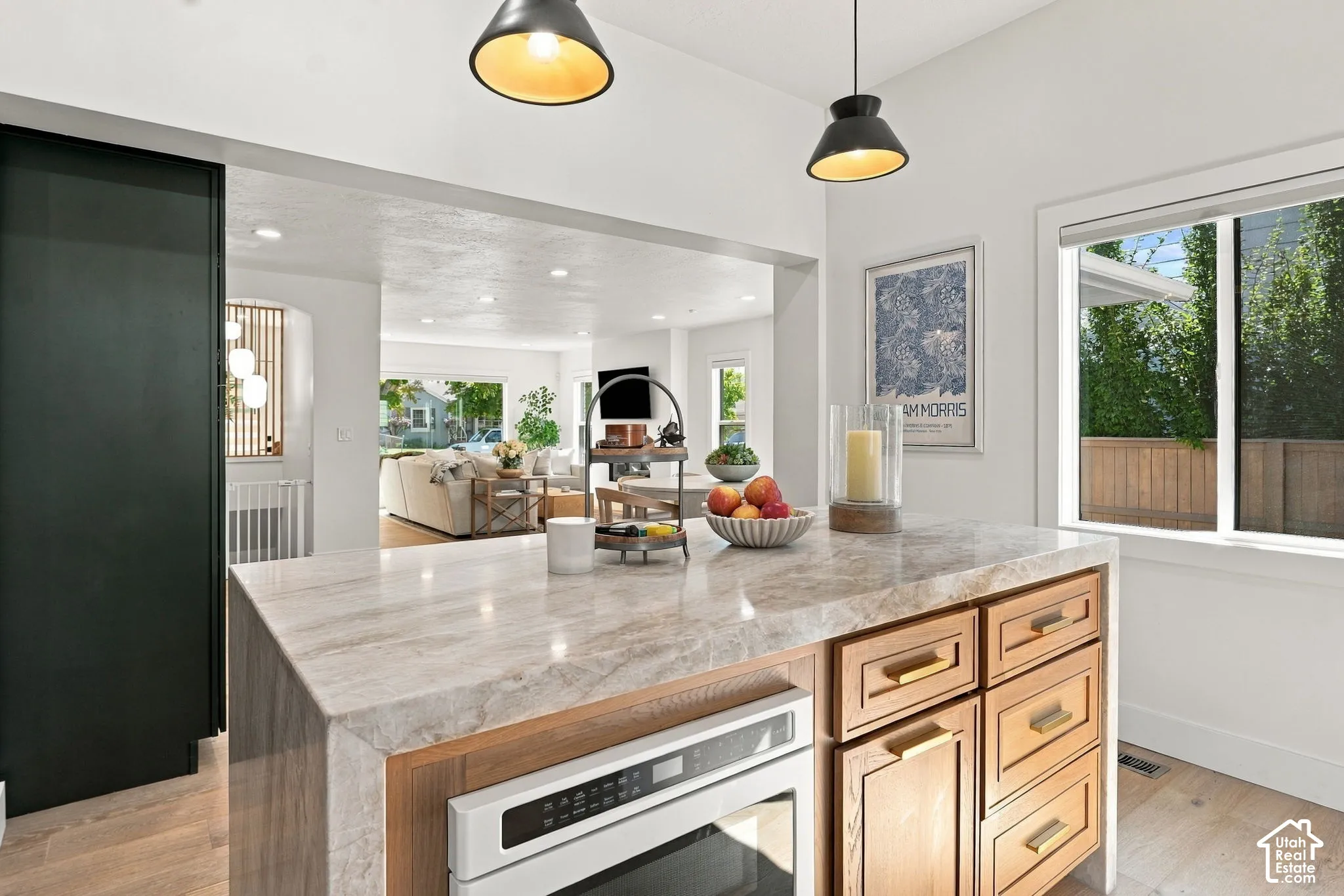 Kitchen island featuring a stone-finish countertop, wood-finish cabinetry, and an integrated oven