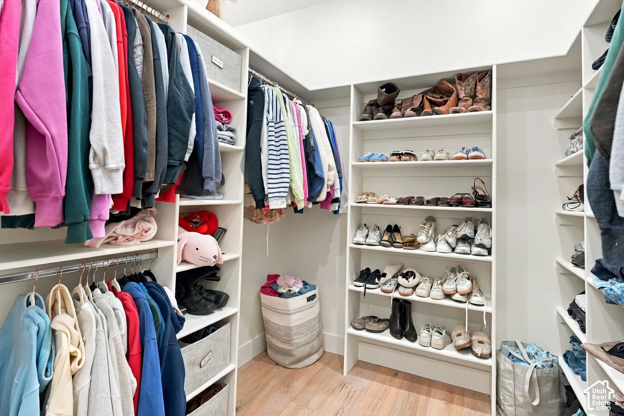Built-in closet system with multiple hanging rods, integrated shelving, and dedicated storage compartments