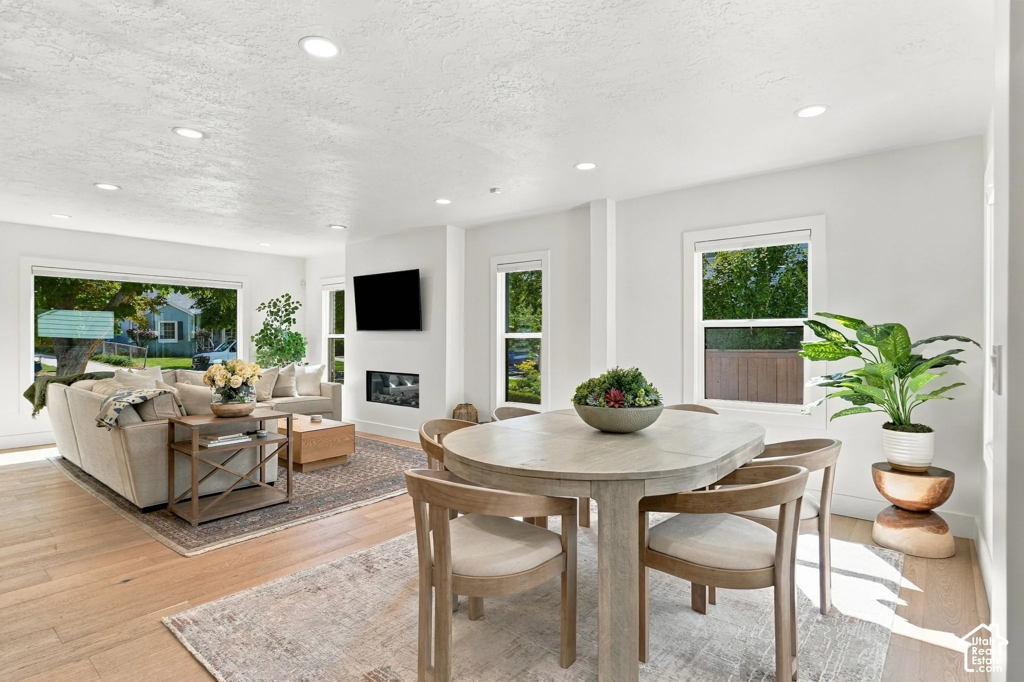 Hardwood flooring, recessed lighting, large windows, and a modern fireplace