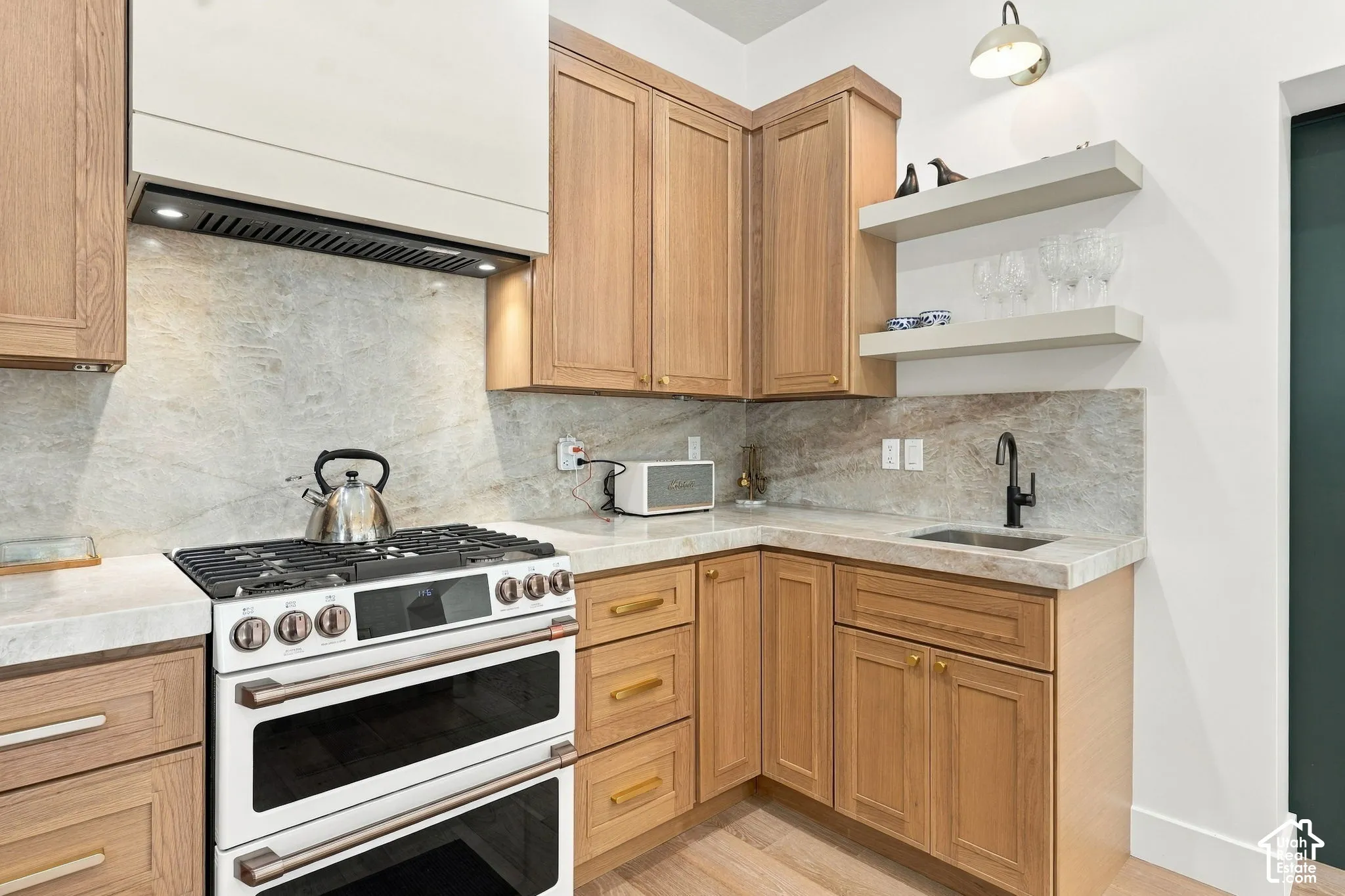 Neutral-toned cabinetry, light-hued countertops, and a stone-finish backsplash