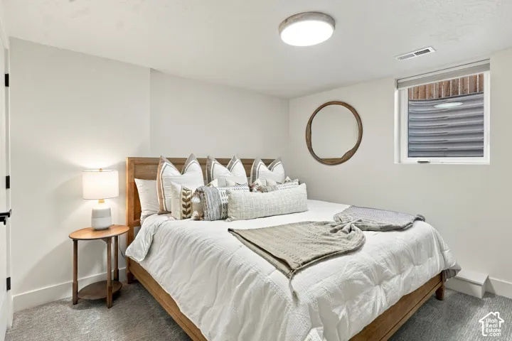 Light-colored carpeting with a window and roller shade