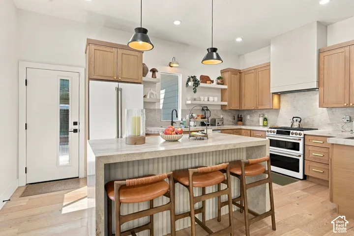 Gourmet kitchen featuring a center island, light wood-finish cabinetry, built-in range, and recessed lighting