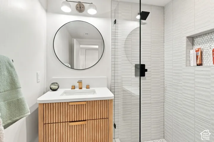 Glass-enclosed shower with textured wall tile and a recessed niche