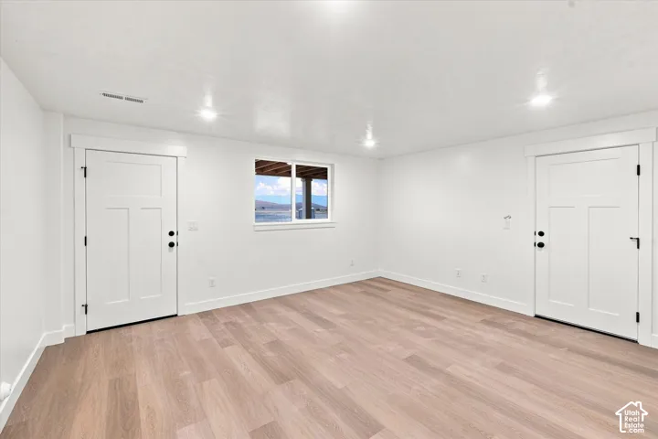 Recessed ceiling lighting illuminates the light wood-finish flooring