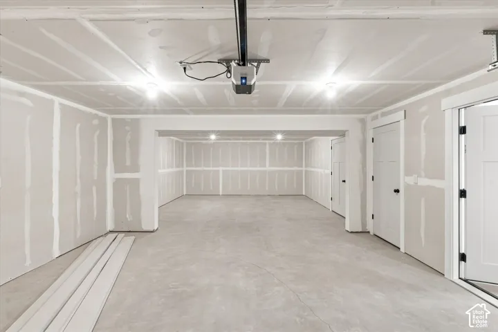 Unfinished basement with concrete flooring, recessed lighting, multiple interior doors, and exposed drywall