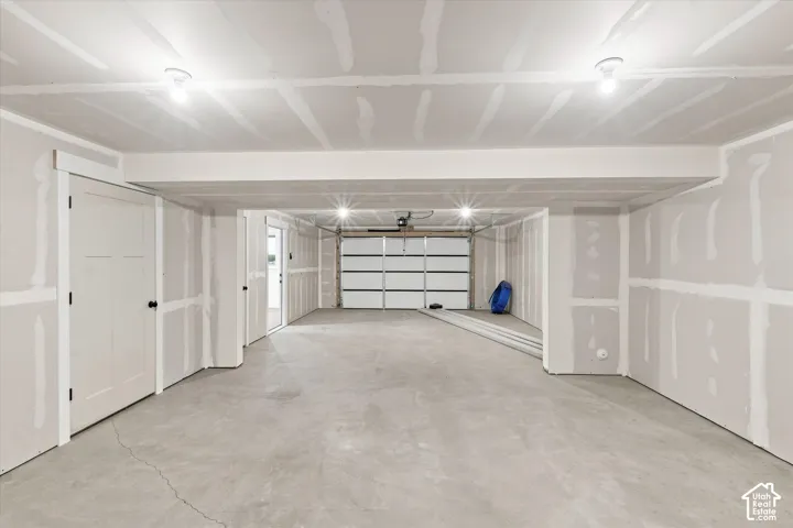Unfinished interior space with exposed drywall and a concrete floor
