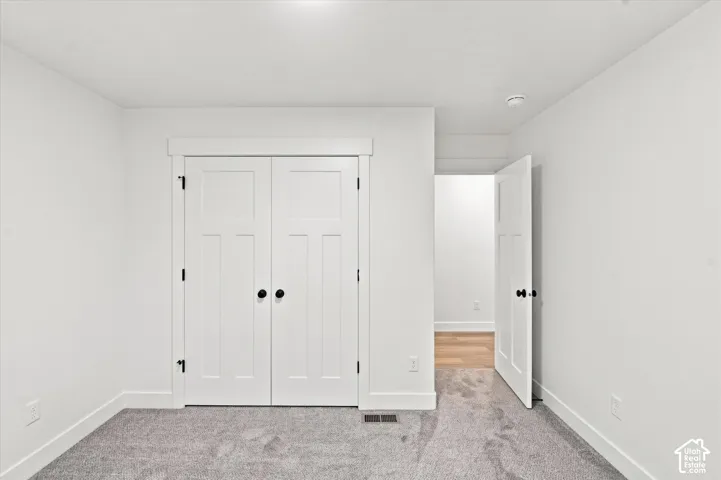 White shaker-style closet doors with black hardware
