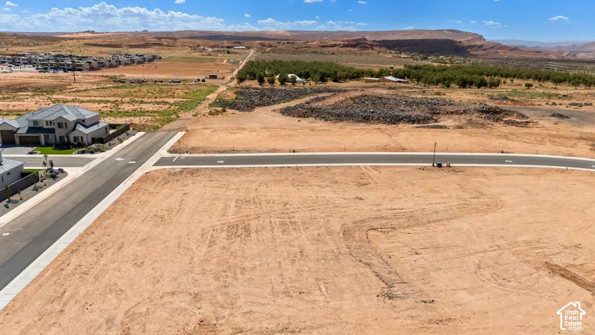 Paved street access, desert landscape, and distant natural rock formations