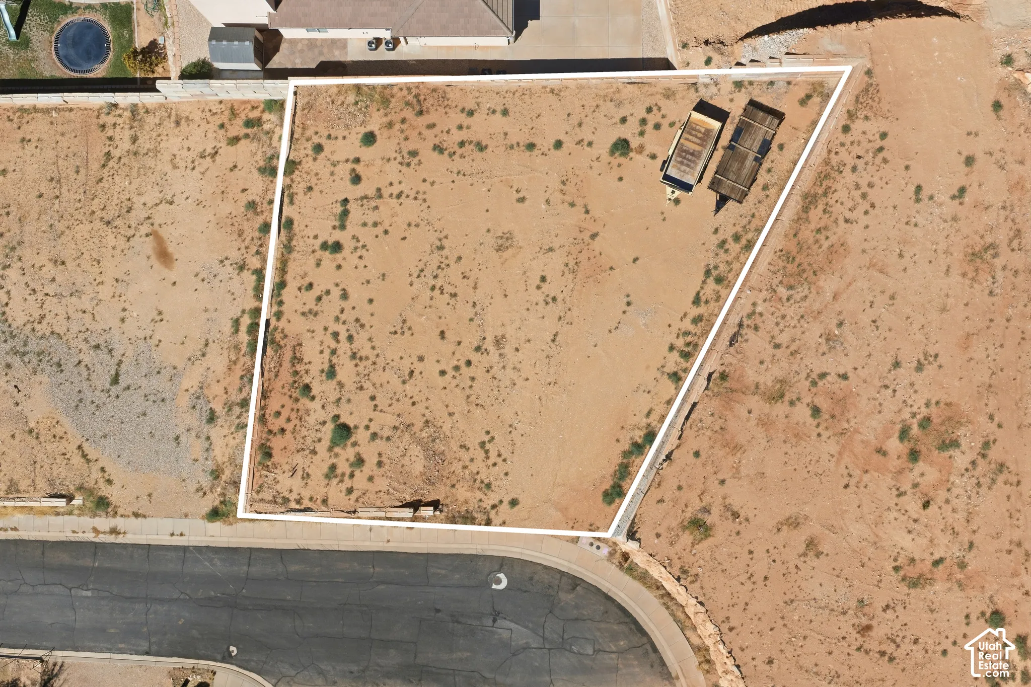 Expansive vacant lot with a defined property line, bordering a paved street
