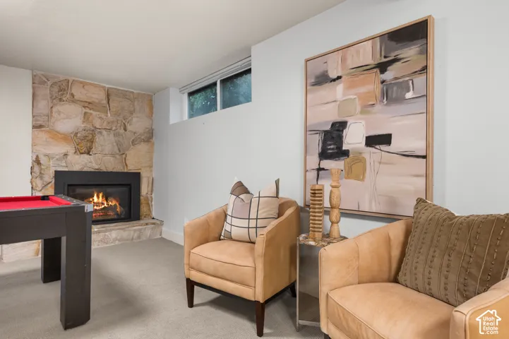 Stone-clad fireplace with a raised hearth, broad-frame window, and neutral wall paint