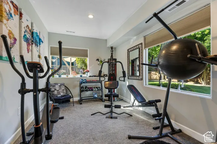 Carpeted room with recessed lighting and multiple windows