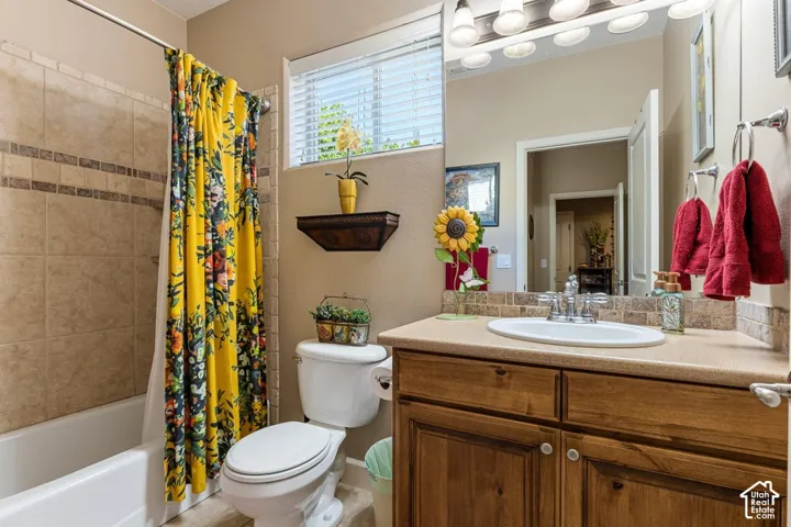 Bathroom featuring a built-in tub with tile surround, wood-finish vanity with an integrated sink, and a large wall-mounted mirror