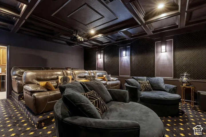 Coffered ceiling with recessed lighting, patterned wall accents, wall-mounted sconces, and a ceiling-mounted projector